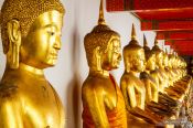 Travel photography:Row of golden Buddhas at Wat Pho temple in Bangkok, Thailand
