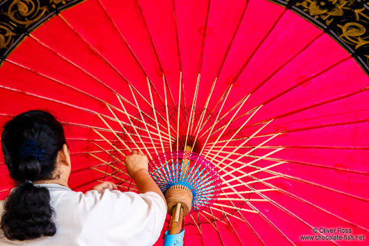 Adding the finishing touches to a large parasol at the Bo Sang parasol factory
