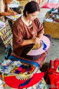 Travel photography:Woman painting a fan at the Bo Sang parasol factory, Thailand