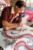Travel photography:Man painting a cover at the Bo Sang parasol factory, Thailand