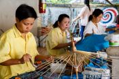 Travel photography:Women assembling the wooden parasols at the Bo Sang parasol factory, Thailand