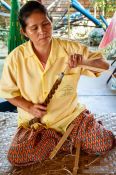 Travel photography:Woman using a hand drill at the Bo Sang parasol factory, Thailand