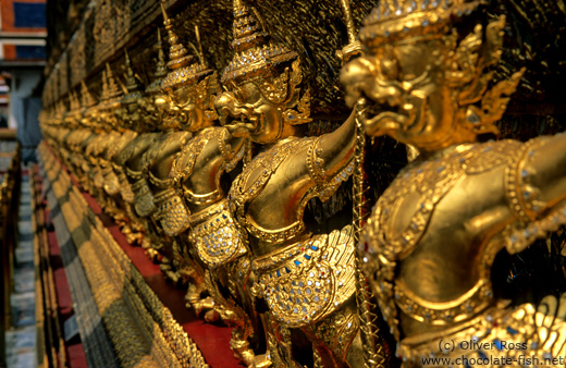 Row of golden garuda figures outside the main building of Wat Phra Kaew in Bangkok