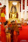 Travel photography:Yound monks decorating Wat Chedi Luang Worawihan in Chiang Mai, Thailand