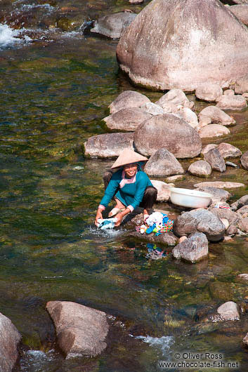 Woman washing clothes in a river near Sapa