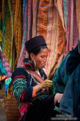 Travel photography:Hmong woman in front of her handy work in Sapa, Vietnam