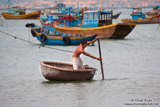 Man in a typical round boat in Mui Ne 