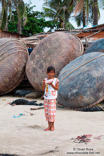 Girl in front of the round boats typical for Mui Ne 
