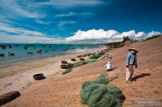 Women drying fish at the wharf at Mui Ne 