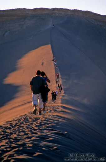 People walking on sand dune near the Valley de la Luna, San Pedro de Atacama